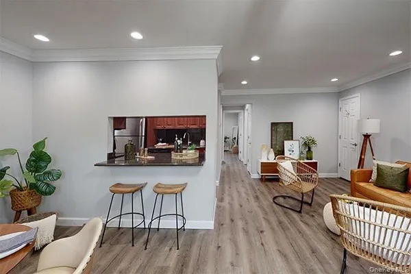 a living room with furniture a flat screen tv and kitchen view