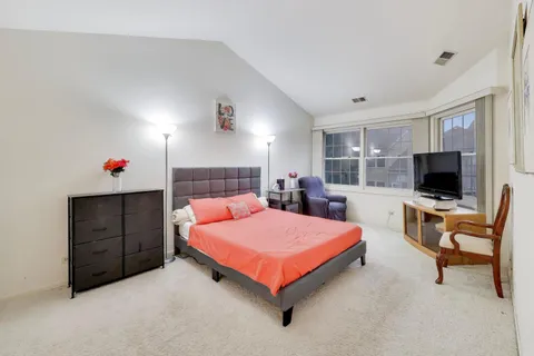 a bedroom with a bed and a flat screen tv