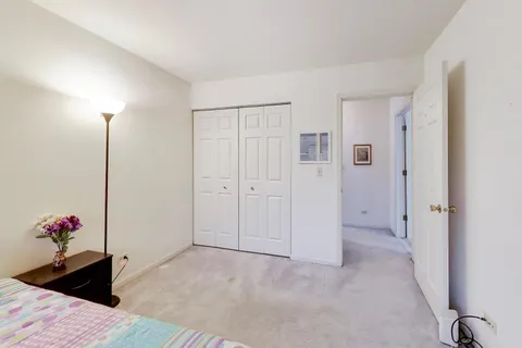 a view of a bedroom with wooden floor & closet