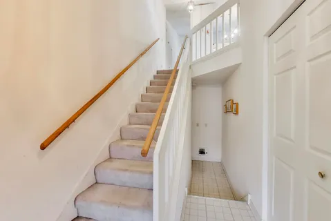 a view of staircase with white walls and windows