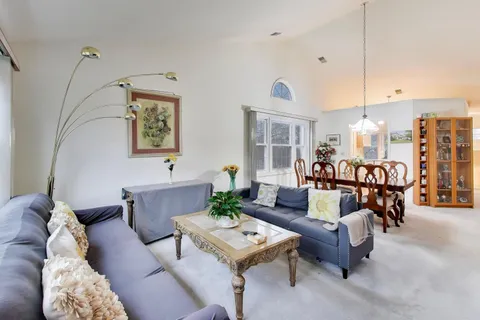 a living room with furniture and view of kitchen
