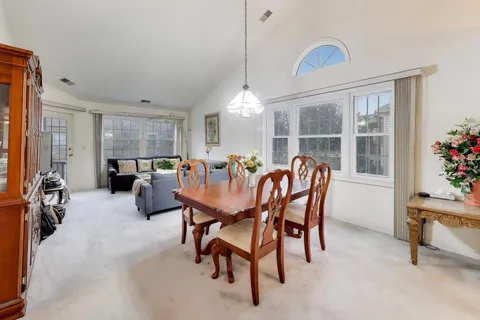 a view of a dining room and livingroom with furniture window and wooden floor