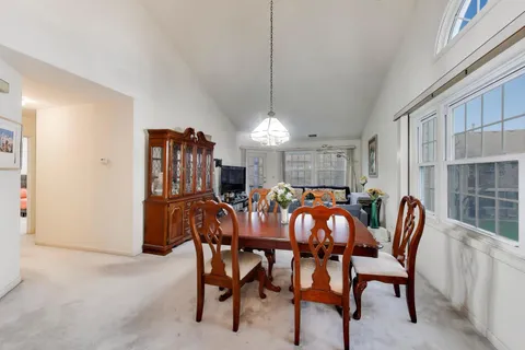 a view of a dining room with furniture and chandelier