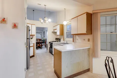 a kitchen with kitchen island a sink stove and refrigerator