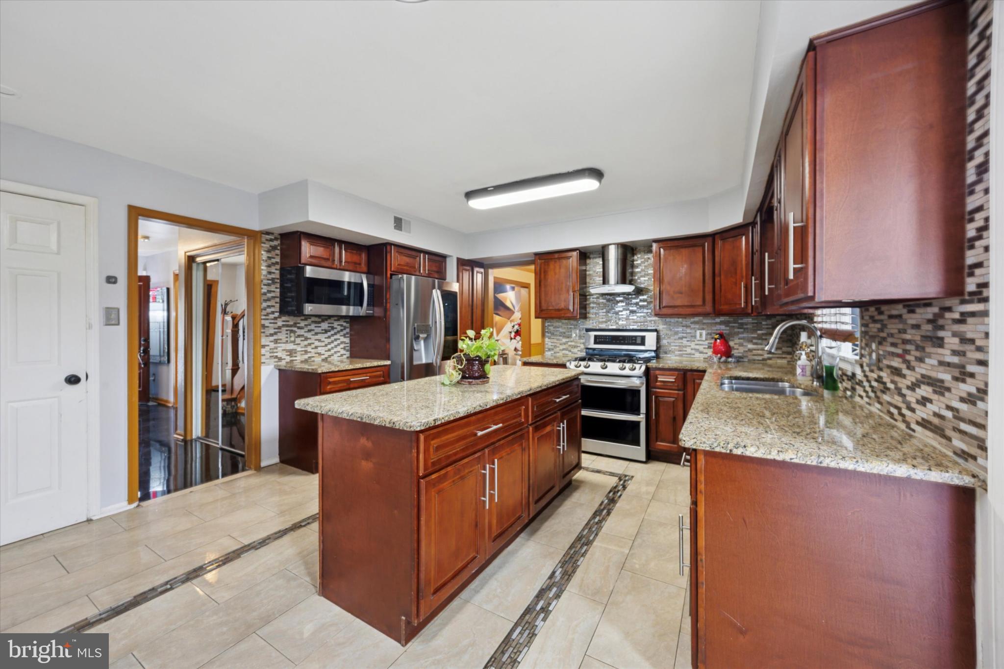 506 Flora Circle Springfield, PA 19064 - Photo 6 of 35 a kitchen with stainless steel appliances granite countertop a stove top oven a sink and a refrigerator