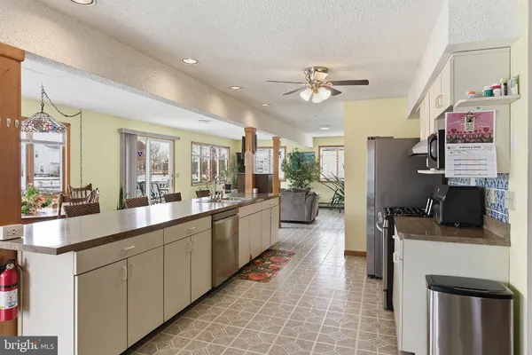 a large kitchen with kitchen island a counter space a sink and appliances