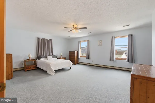 a spacious bedroom with a bed and a chandelier