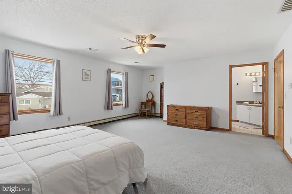 a spacious bedroom with a bed and a chandelier