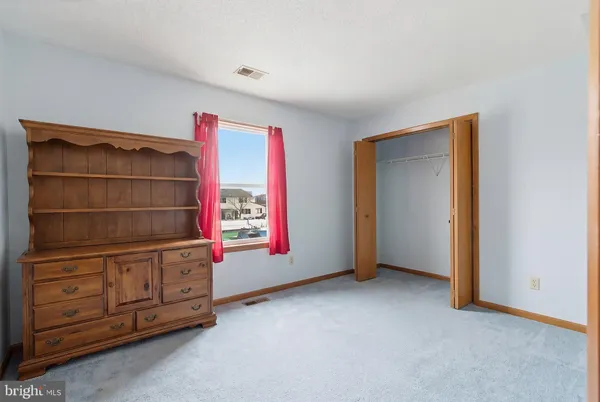 an empty room with cabinet and windows