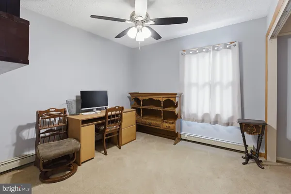 a view of a livingroom with workspace and a window