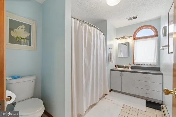 a bathroom with a granite countertop sink mirror vanity and toilet
