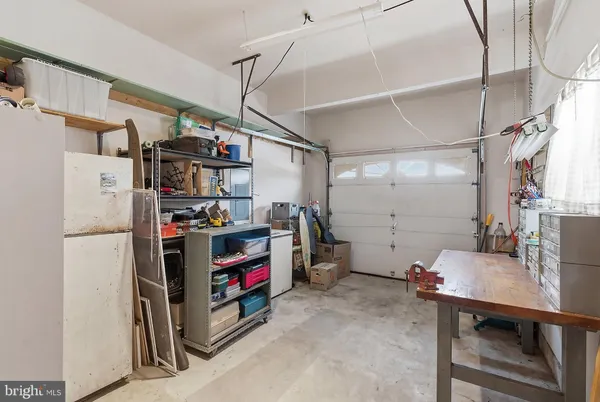 a view of a storage & utility room with fridge and stairs