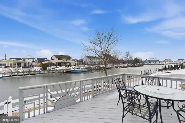 a view of a chairs and table on wooden floor with a lake view
