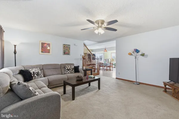 a living room with furniture and a ceiling fan