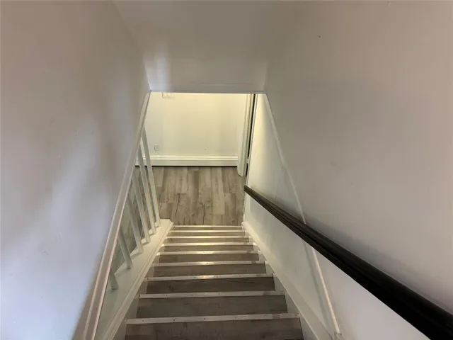 a view of an empty room with wooden floor and closet