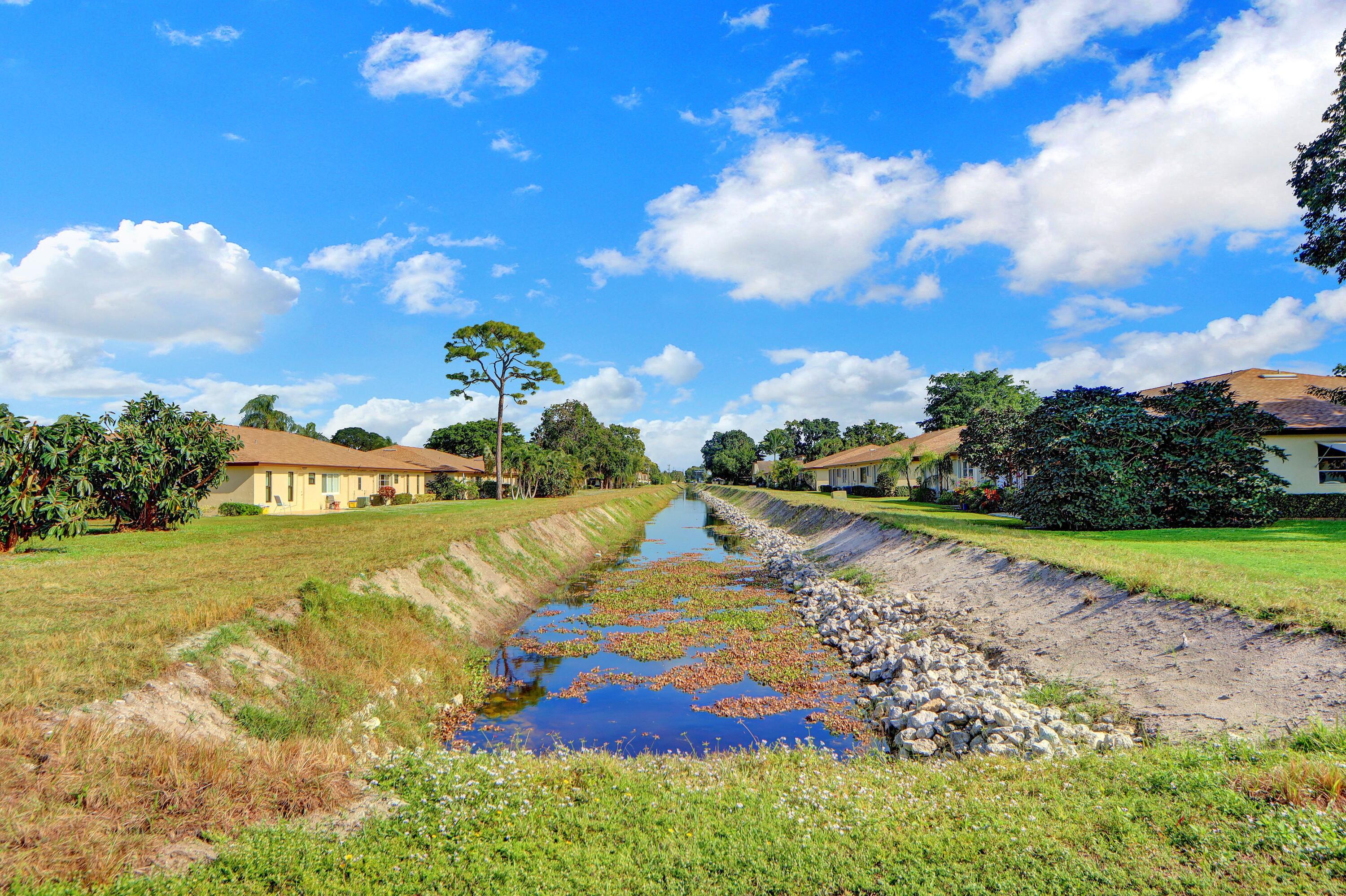 14050 Nesting Way, Unit B Delray Beach, FL 33484 - Photo 3 of 17 a view of a lake with a yard