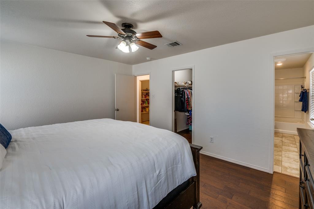 728 Falcon Road Saginaw, TX 76131 - Photo 21 of 30 a bedroom with a bed and a chandelier