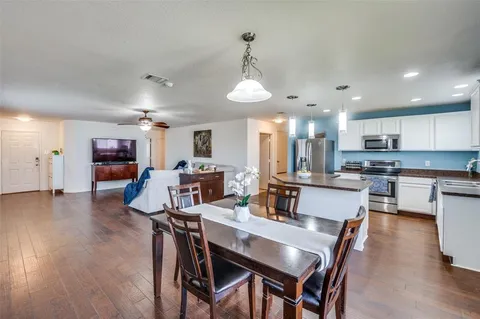a view of a dining room and livingroom with furniture wooden floor a chandelier