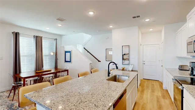 a kitchen with kitchen island a sink a stove and a refrigerator