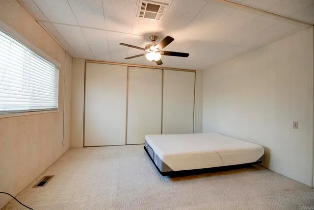a bedroom with a bed and a ceiling fan