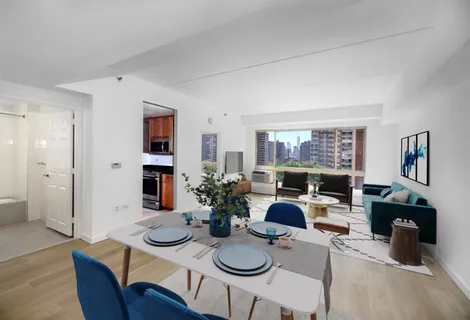 a view of a dining room with furniture one side kitchen view and wooden floor