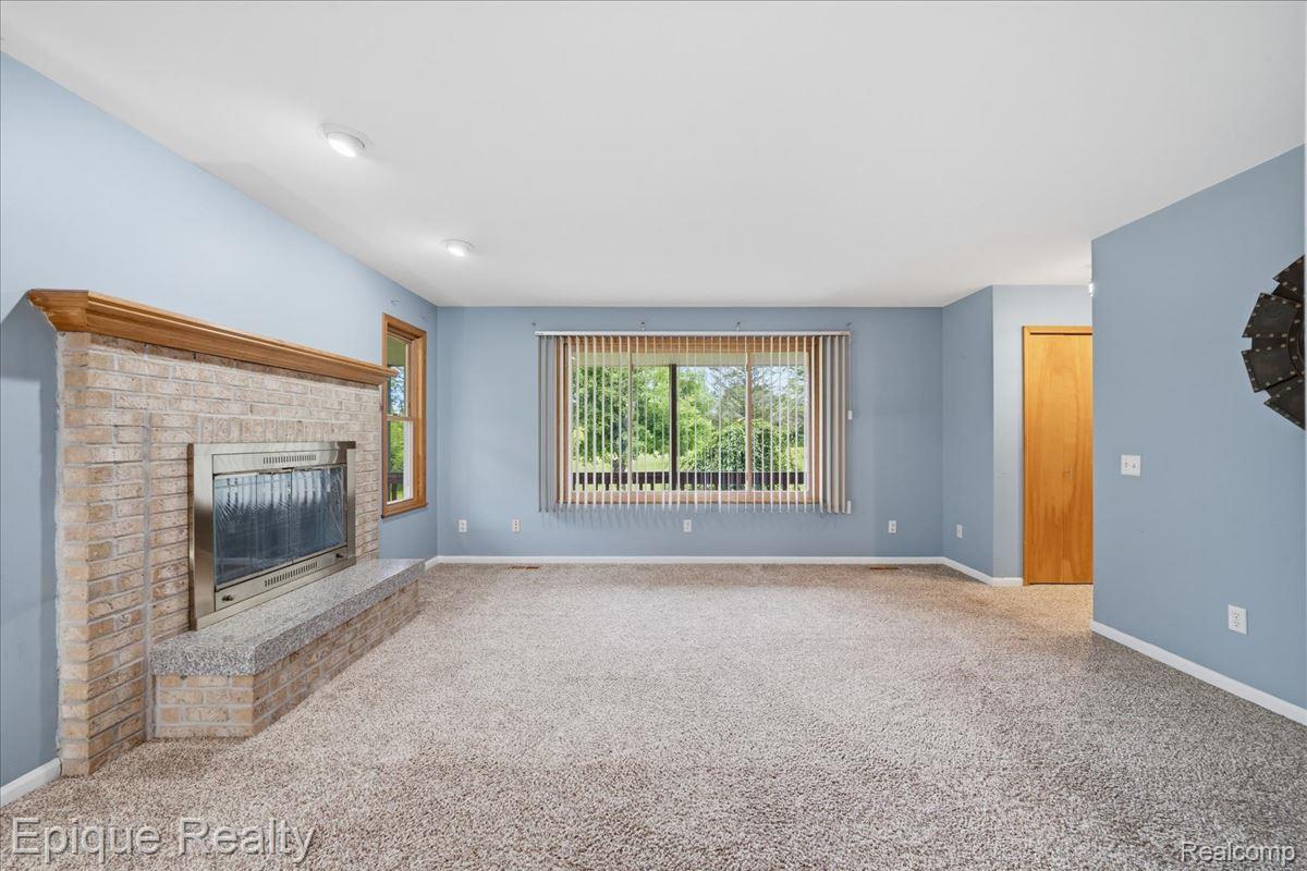 1221 Rhodes Road Lake Orion, MI 48360 - Photo 21 of 72 Brick fireplace with a wood mantel and stone hearth
