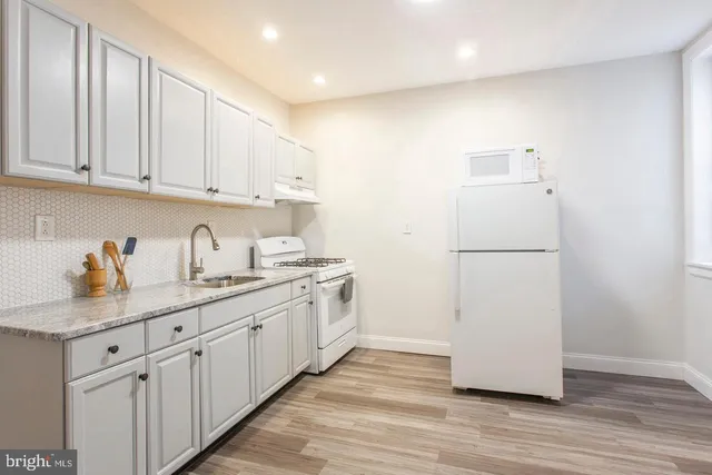 a kitchen with sink cabinets and wooden floor