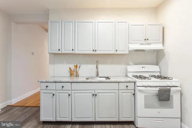 a kitchen with granite countertop white cabinets and white appliances