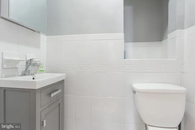 a bathroom with a sink a toilet and a mirror