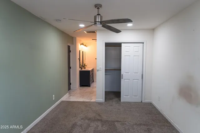 an empty room with a ceiling fan and shower