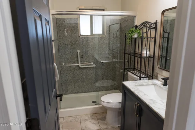 a bathroom with a sink a toilet and shower