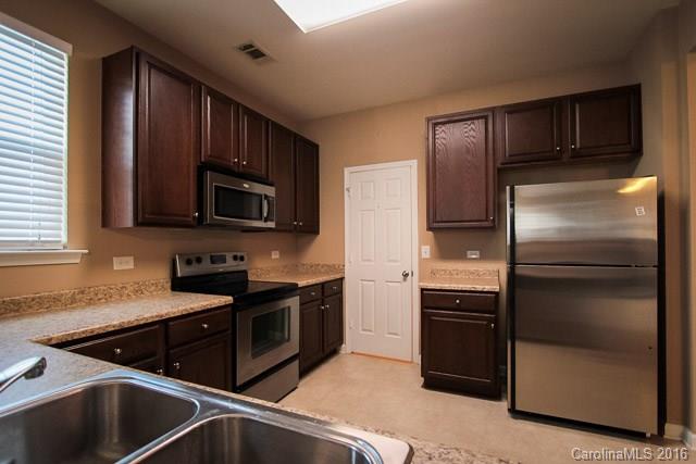 241 River Clay Road, Unit 179 Fort Mill, SC 29708 - Photo 3 of 24 a kitchen with stainless steel appliances wooden cabinets a sink and a stove