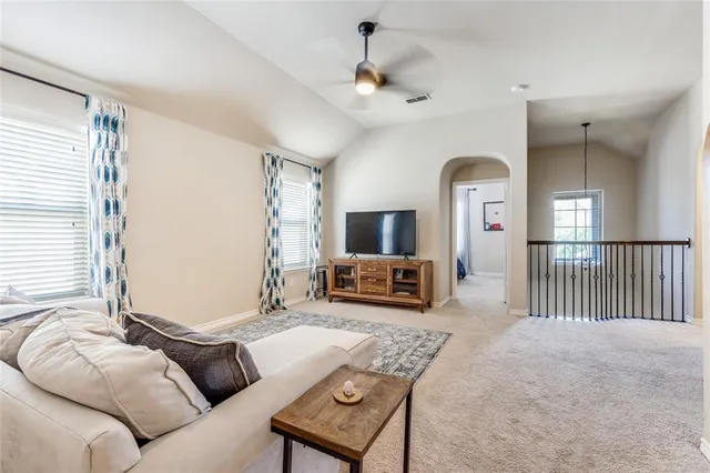 a living room with furniture a large window and a flat screen tv