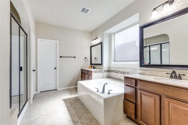 a bathroom with a tub sink and mirror