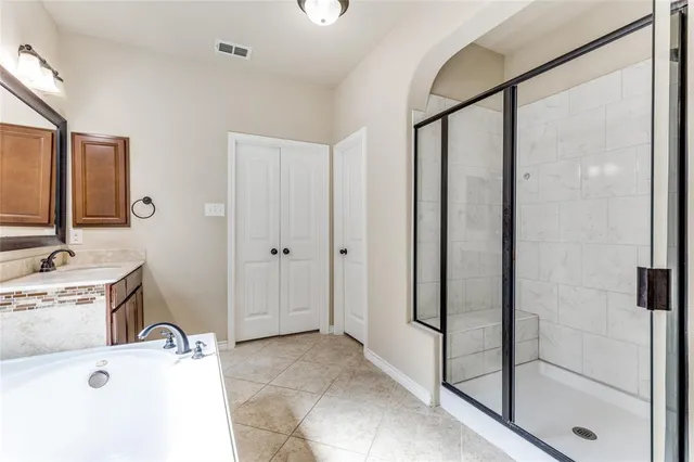 a bathroom with a tub sink shower and mirror