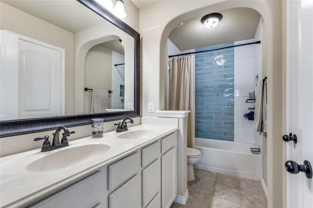 a bathroom with a double vanity sink toilet mirror and shower