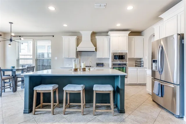 a kitchen with a table chairs refrigerator and cabinets