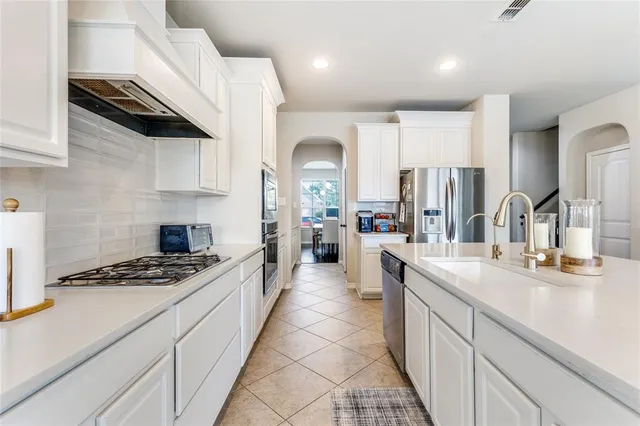 a kitchen with kitchen island granite countertop a sink stainless steel appliances and cabinets
