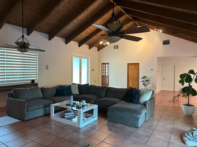 a living room with furniture and a ceiling fan