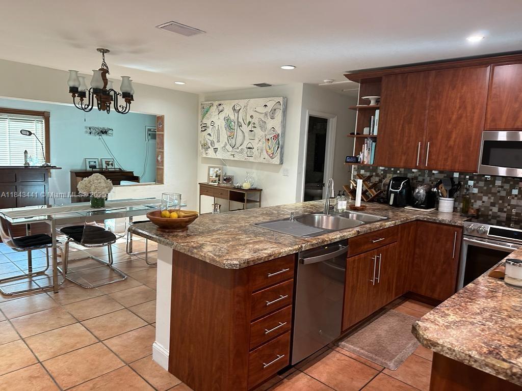 10375 Southwest 111th Street Miami, FL 33176 - Photo 16 of 30 a kitchen with a stove a sink and a refrigerator