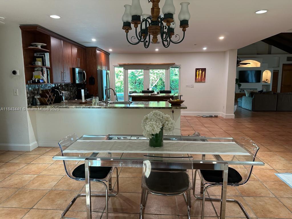 10375 Southwest 111th Street Miami, FL 33176 - Photo 19 of 30 a kitchen with kitchen island stainless steel appliances a table chairs in it and wooden floor
