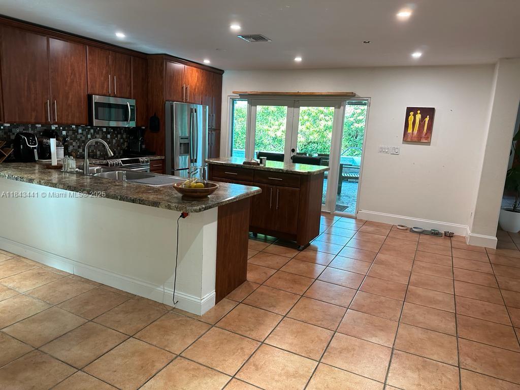 10375 Southwest 111th Street Miami, FL 33176 - Photo 20 of 30 a kitchen with stainless steel appliances granite countertop a sink and a stove