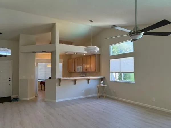 a view of an empty room with a window and wooden floor
