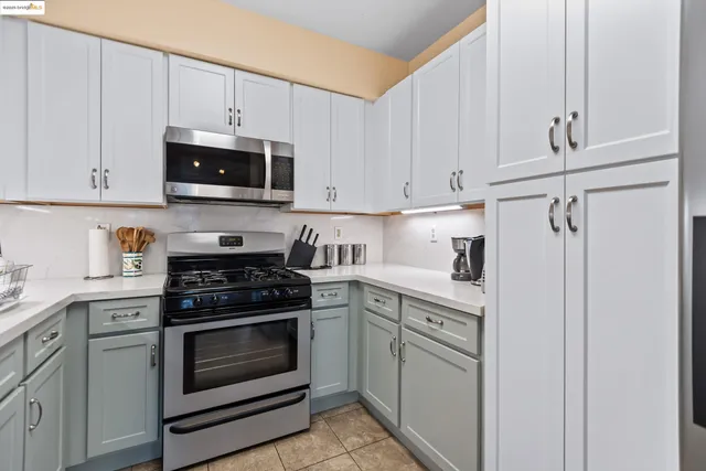 a kitchen with white cabinets and stainless steel appliances