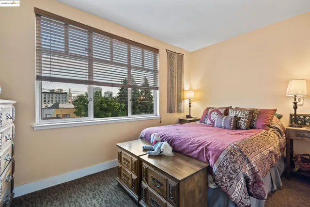 a bedroom with a bed next to a window