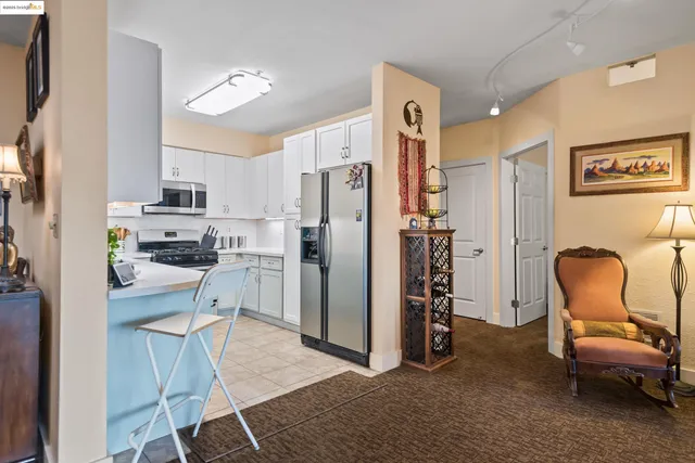 a kitchen with stainless steel appliances granite countertop a refrigerator and a stove top oven