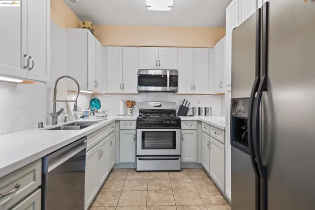 a kitchen with stainless steel appliances granite countertop a refrigerator sink and cabinets