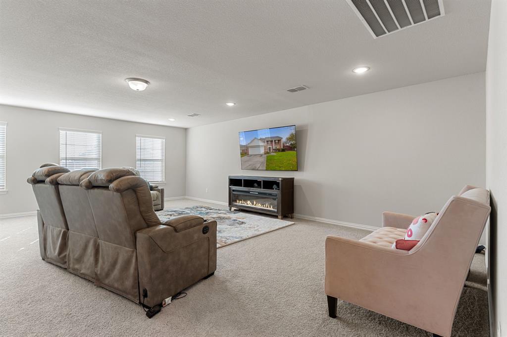 2012 Elara Drive Haslet, TX 76052 - Photo 21 of 34 a living room with furniture a fireplace and a flat screen tv