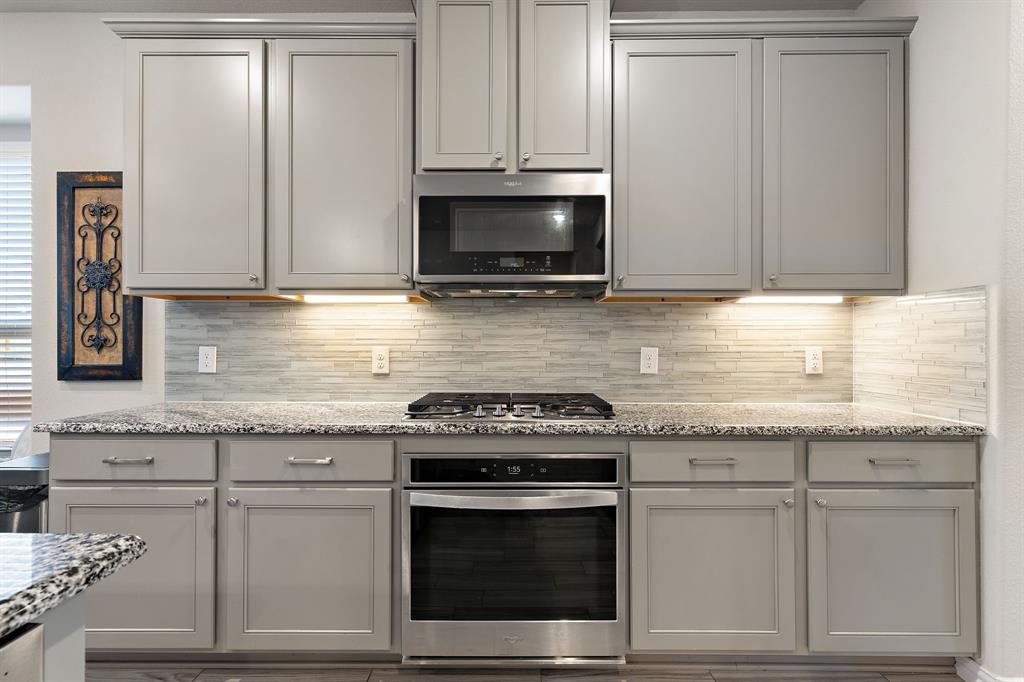 2012 Elara Drive Haslet, TX 76052 - Photo 7 of 34 a kitchen with granite countertop white cabinets and stainless steel appliances