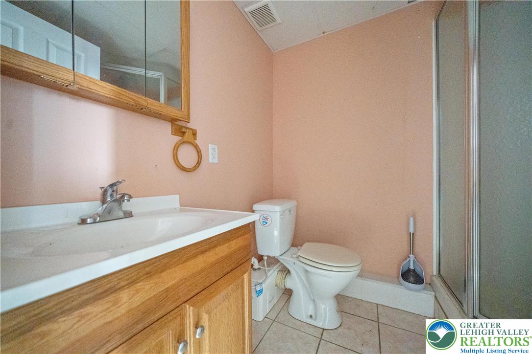 664 Cranberry Road, Unit 1 East Stroudsburg, PA 18301 - Photo 18 of 22 a bathroom with a granite countertop sink toilet and a mirror